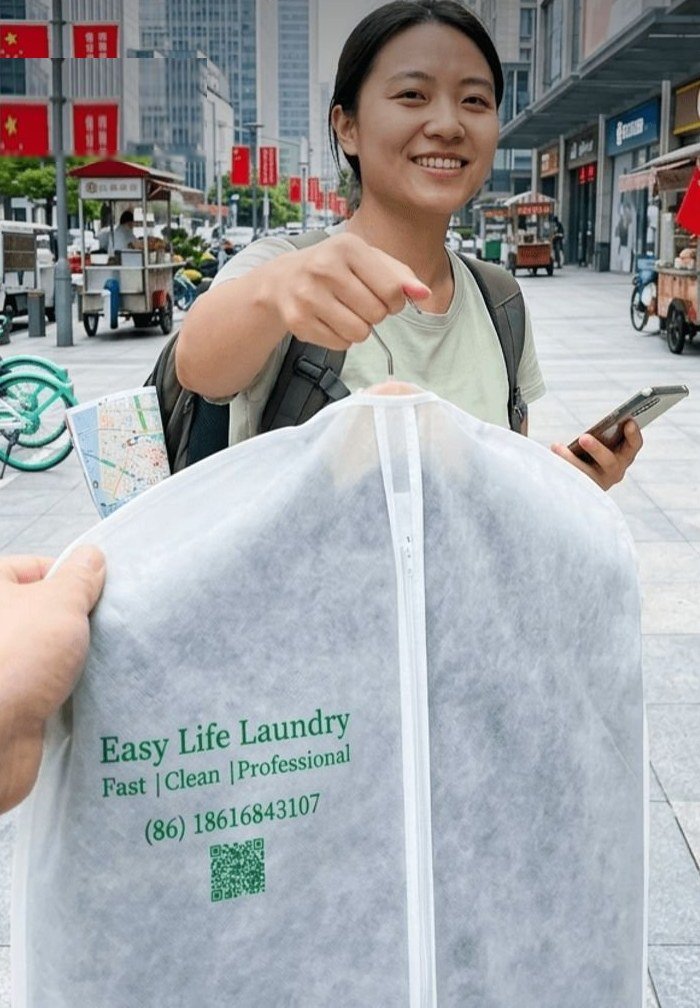 Smiling customer in Shanghai handing over clothes in an Easy Life Laundry garment bag for dry cleaning pickup