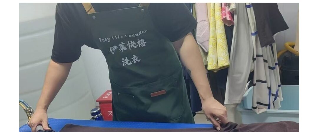 Easy Life Laundry staff pressing a garment by hand, Hangzhou