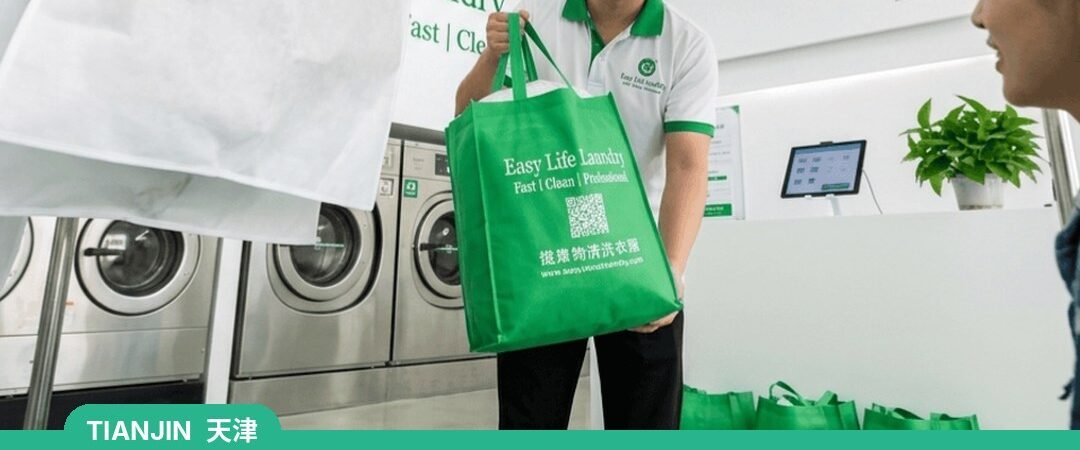 Easy Life Laundry staff handing over a bag at a laundry shop, Tianjin